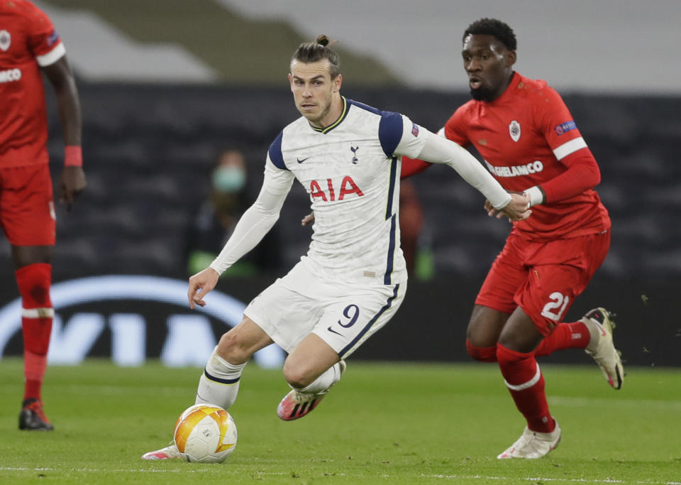 Gareth Bale, centro, del Tottenham, trata de zafarse de la marca de Dylan Batubinsika, del Antwerp, en duelo por el Grupo J de la Liga Europa en el estadio Tottenham Hotspur de Londres, el jueves 10 de diciembre de 2020. (AP Foto/Kirsty Wigglesworth, pool)