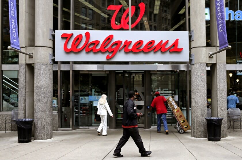 FILE - In this June 4, 2014, file photo, people walk in to a Walgreens retail store in Boston. Walgreens slashed its 2019 forecast and missed second-quarter expectations with a performance that sent its shares plunging Tuesday, April 2, 2019 and knocked down the Dow Jones industrial average. The nation's largest drugstore chain said it now expects adjusted earnings per share to be roughly flat this year after confirming as recently as late December a forecast for growth of 7% to 12%. (AP Photo/Charles Krupa, File)