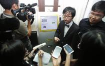 Tembusu Terminals' partners Peter Peh Sik Wee (2nd R) and Jarrod Luo (R) speak to the media before launching the first Bitcoin vending machine at a pub in Singapore February 27, 2014. According to Tembusu Terminals, this is the first Bitcoin vending machine in Asia. REUTERS/Edgar Su