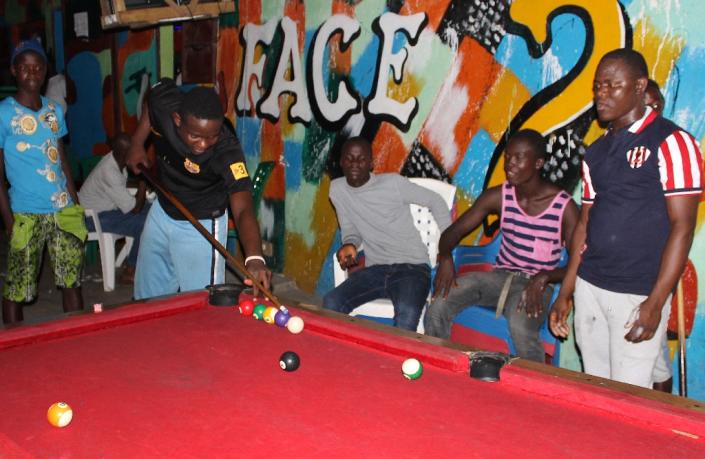 People play pool in Monrovia on February 22, 2015, enjoying their first night of freedom since an Ebola curfew was lifted (AFP Photo/Zoom Dosso)