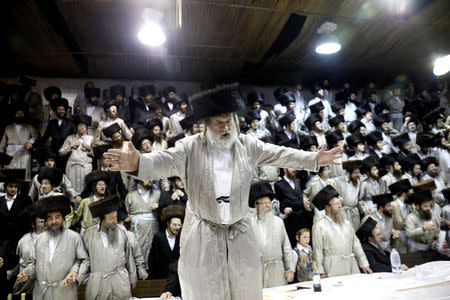 An Ultra-Orthodox Jewish man dances on the table during the celebrations of Simchat Torah in a synagogue at the Mea Shearim neighbourhood of Jerusalem October 1, 2018. REUTERS/Ronen Zvulun