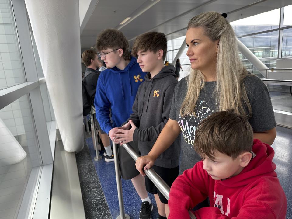 Mitzi Hale and her three sons look out a window at backed-up traffic due to the closure of Detroit Metropolitan Airport's McNamara Terminal on Thursday, Aug. 24, 2023, in Romulus, Mich. A flight originating from McNamara that was scheduled to take Hale and her boys to Florida for a vacation was delayed. Parts of Michigan received more than 5 inches of rain, which flooded tunnels leading to Detroit's main airport. (AP Photo/Mike Householder)