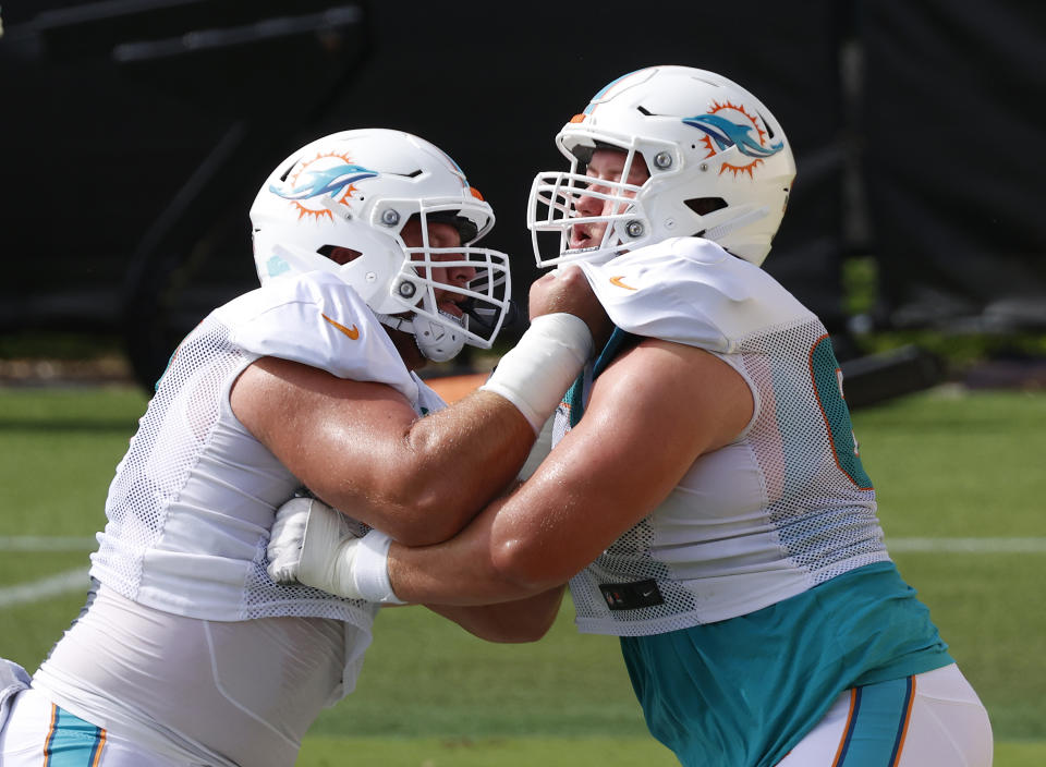 Miami Dolphins center Ted Karras (67), left, and guard Michael Deiter (63) run a drill during an NFL football training camp practice in Davie, Fla., Monday, Aug. 17, 2020. (AP Photo/Joel Auerbach)