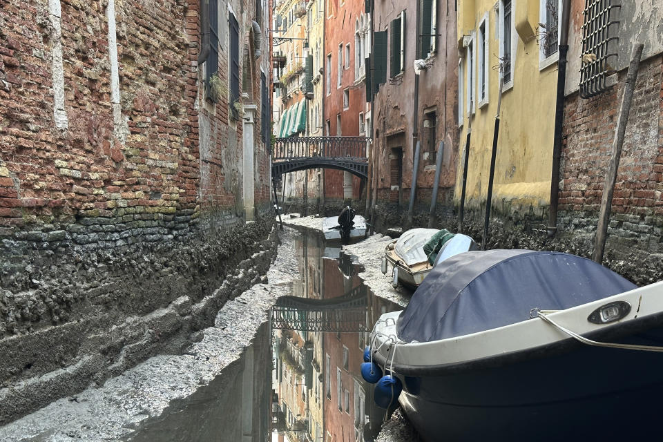 Boats are docked along a canal during a low tide in Venice, Italy, Monday, Feb. 20, 2023. Some ofVenice's secondary canals have practically dried up lately due a prolonged spell of low tides linked to a lingering high-pressure weather system. (AP Photo/Luigi Costantini)