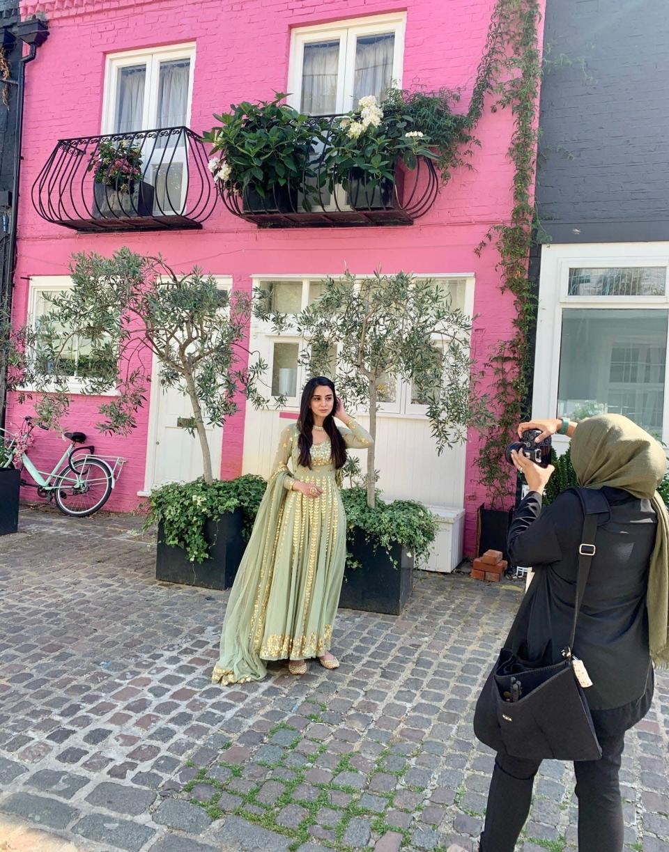 Beauty influencer Gulshan shoots outfit photos outside of the pink house on St. Lukes Mews.