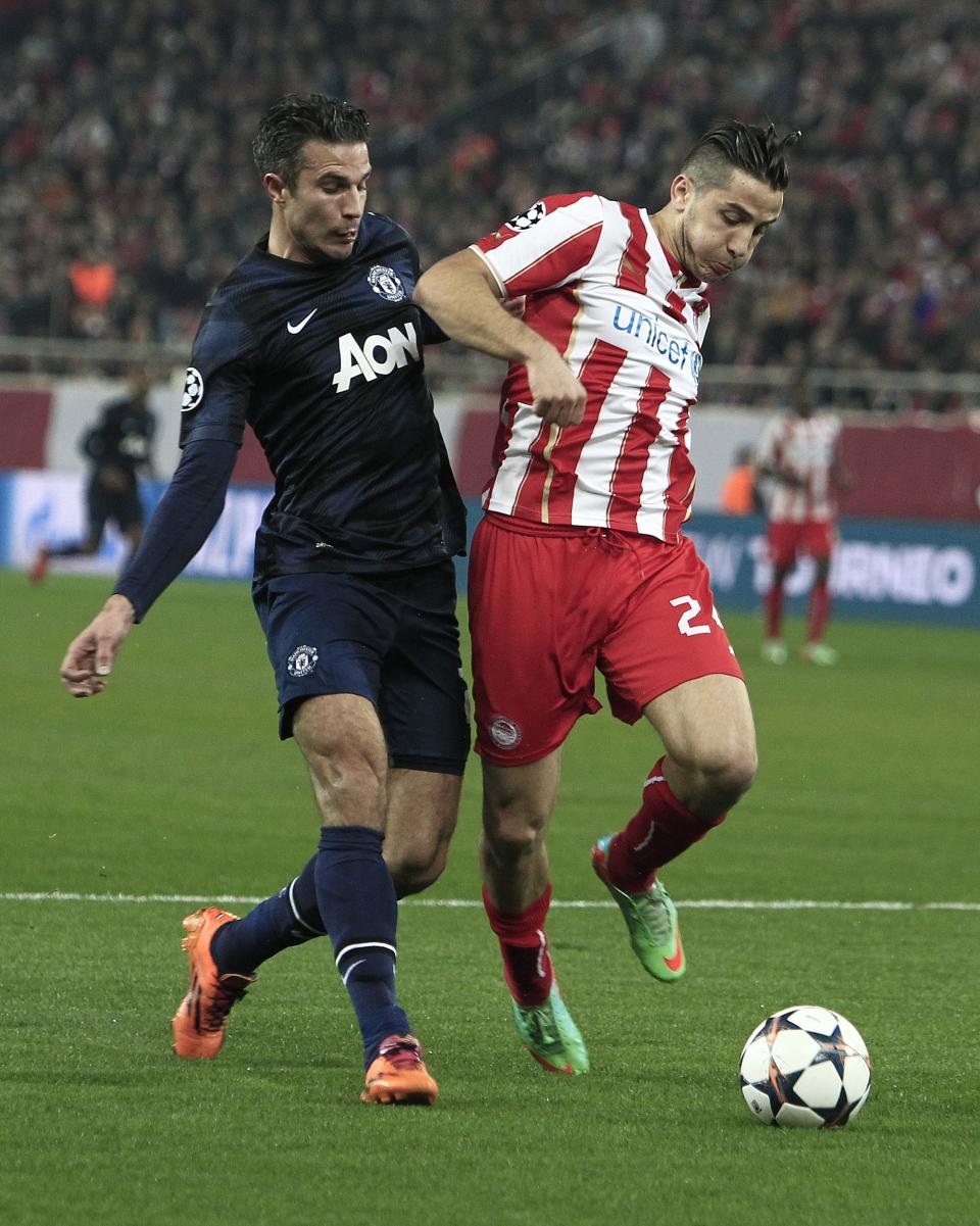 Olympiakos' Kostas Manolas, right, stops the ball ahead of Manchester United's Robin van Persie during their Champions League, round of 16, first leg soccer match at Georgios Karaiskakis stadium, in Piraeus port, near Athens, on Tuesday, Feb. 25, 2014. (AP Photo/Thanassis Stavrakis)