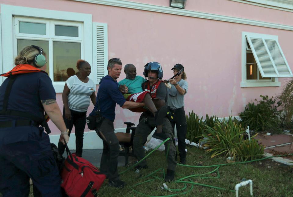 Members of US' Coast Guard evacuate a man from a hospital in Marsh Harbor, Abaco Island, Bahamas, Friday, Sept. 6, 2019. The Bahamian health ministry said helicopters and boats are on the way to help people in affected areas, though officials warned of delays because of severe flooding and limited access.(AP Photo/Fernando Llano) ORG XMIT: XFLL124