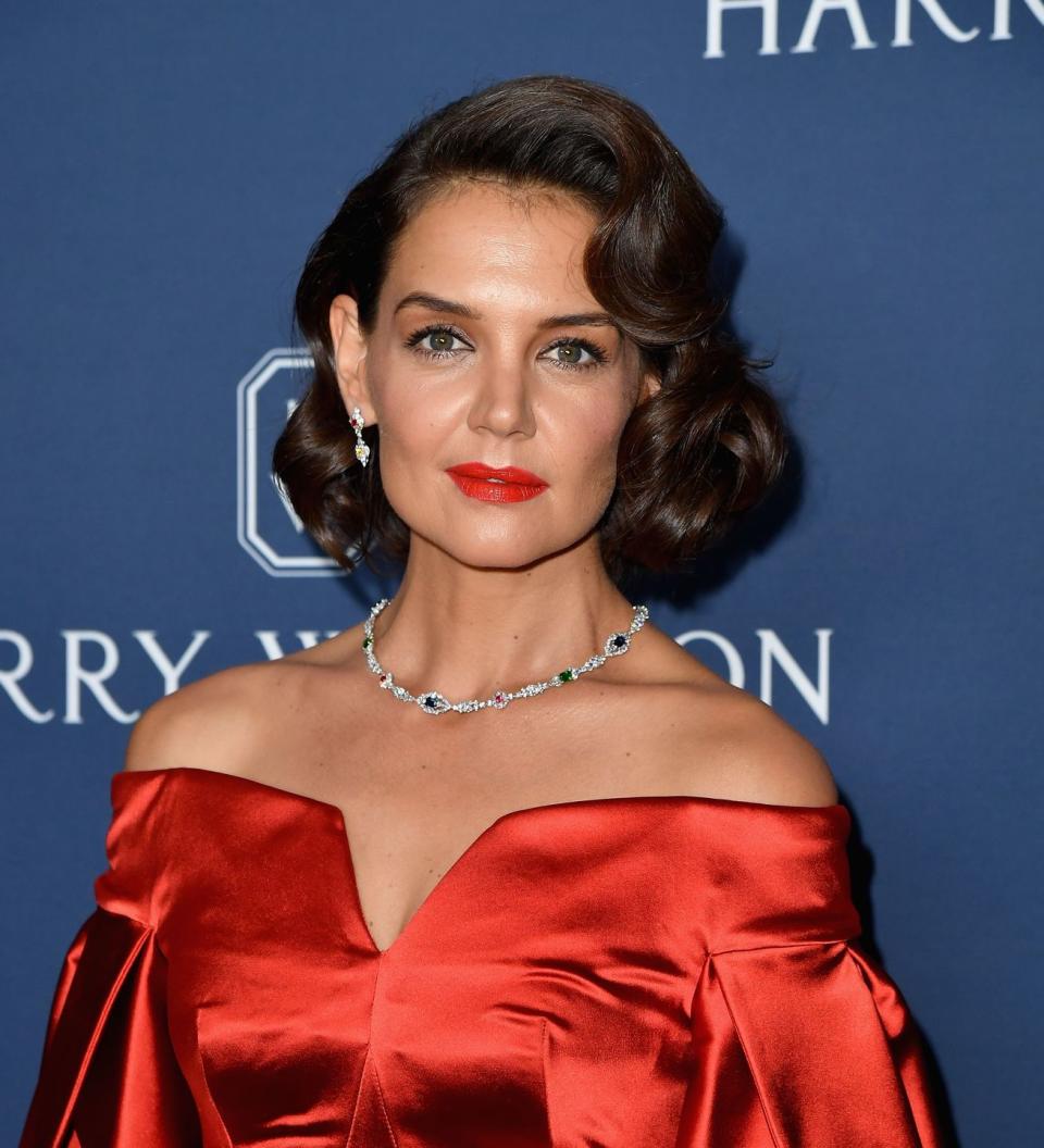 Katie Holmes in a red off the shoulder dress.