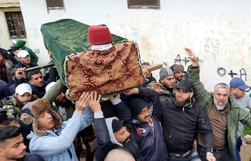 People carry the coffin of a protestor during his funeral in Tripoli