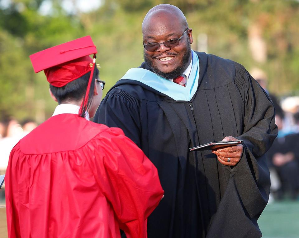 North Quincy High Principal Keith Ford hands out a diploma at Veterans Memorial Stadium on Monday, June 6, 2022.