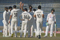 New Zealand's Ish Sodhi, center, celebrates with teammates after taking the wicket of Pakistan's Mohammad Wasim, right, during the fifth day of first test cricket match between Pakistan and New Zealand, in Karachi, Pakistan, Friday, Dec. 30, 2022. (AP Photo/Fareed Khan)
