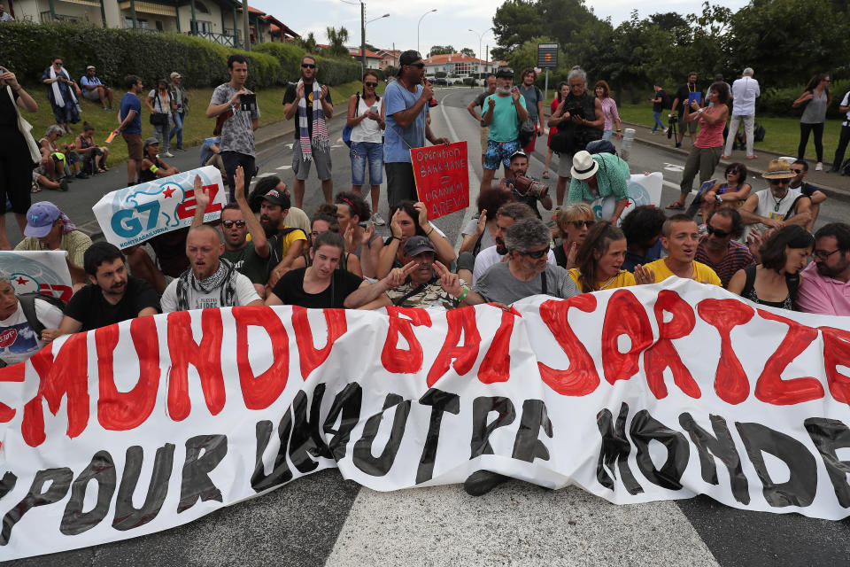 Police block demonstrators, who sit in the road, from entering Biarritz, France on the third and final day of the G-7 summit, Monday, Aug. 26, 2019. (AP Photo/Emilio Morenatti)