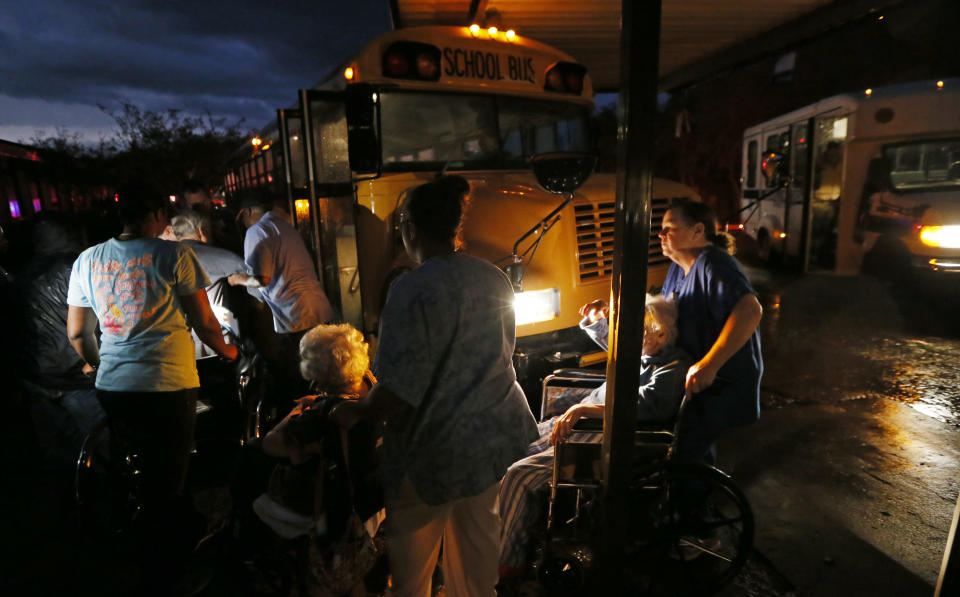 Nursing home personnel assist residents as they are wheeled to a waiting bus outside a Louisville, Miss., nursing home, Monday, April 28, 2014 after the facility and the Winston Medical Center next door were heavily damaged by a tornado. A dangerous storm system that spawned a chain of deadly tornadoes killed dozens from the Midwest to the Deep South. (AP Photo/Rogelio V. Solis)