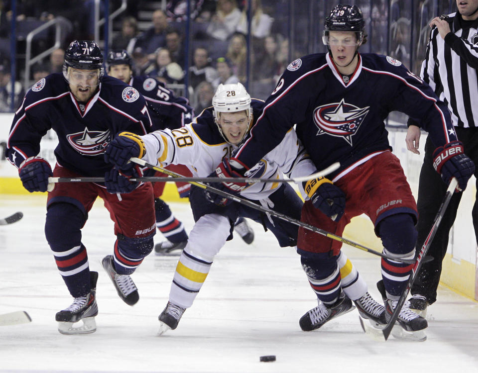 Columbus Blue Jackets' Nick Foligno, left, Ryan Johansen, right, and Buffalo Sabres' Zemgus Girgensons, of Latvia, chase a loose puck during the second period of an NHL hockey game, Saturday, Jan. 25, 2014, in Columbus, Ohio. (AP Photo/Jay LaPrete)