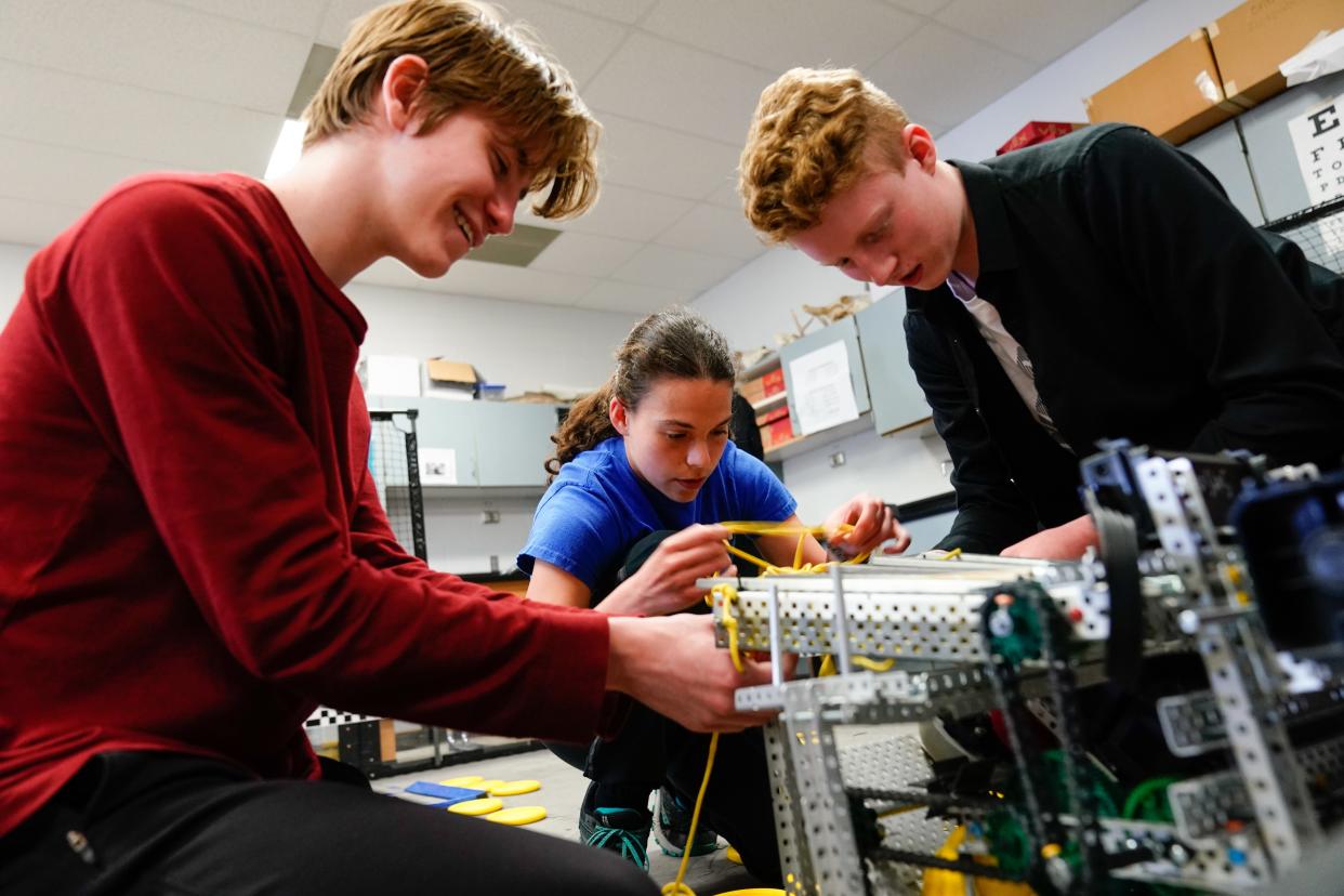 Seaman robotics teammates, from left, sophomore Micah Problesch, junior Kaiden Steichen and sophomore Reese Mumford put together the "end game" strings on their robot during a team practice Thursday.