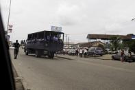 A policeman jogs alongside a truck carrying policewomen on Aba road at Port Harcourt March 30, 2015. REUTERS/Afolabi Sotunde