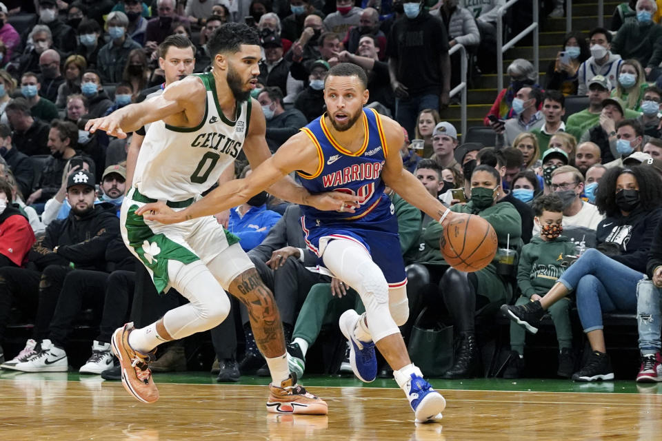 Golden State Warriors guard Stephen Curry (30) drives against Boston Celtics forward Jayson Tatum (0) during the second half of an NBA basketball game, Friday, Dec. 17, 2021, in Boston. (AP Photo/Mary Schwalm)