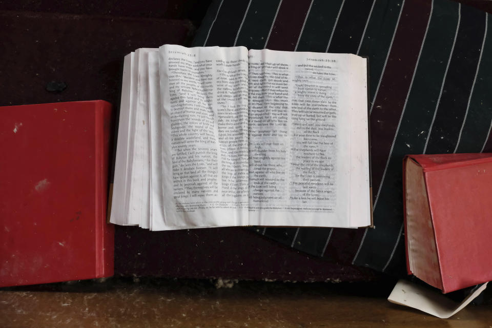 A water-damaged Bible lies open to Jeremiah 25 on a pew inside the Mayfield First United Methodist Church on Sunday, Jan. 9, 2022, in Mayfield, Ky. First United Methodist is one of a half-dozen historic churches in the central core of this western Kentucky community that were destroyed or heavily damaged, all with roots dating back to the 1800s. (AP Photo/Audrey Jackson)