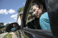 Larry Steele parks his truck outside his mother's trailer home in New Marshfield, Ohio, on Tuesday, July 28, 2020. Larry is a quiet man with a gravelly voice and armfuls of tattoos, a couple of them illegible because "the guy doing the tattoo was drunk." A bout with COVID-19, including three weeks in the hospital, has left him rail thin. He and his partner, Penny Hudnall, survive by supplementing her disability payments with foraging in the woods for wild foods _ walnuts, hickory nuts, paw paws, persimmons, spiceberries _ and selling them to local farmers. (AP Photo/Wong Maye-E)