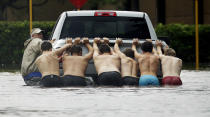 <p>Eine Gruppe von Männern versucht in Houston, Texas, ein steckengebliebenes Auto durch das Hochwasser zu befördern. (Bild: AP Photo/Charlie Riedel) </p>