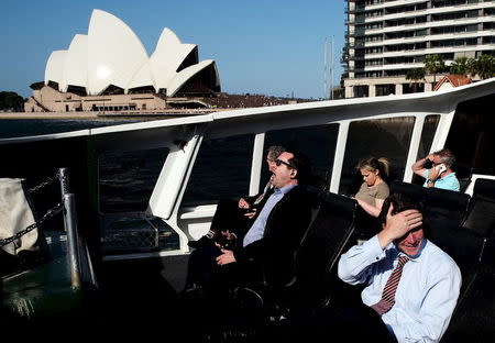 A commuter yawns among others on an open deck ferry between Circular Quay and Rose Bay in Sydney's eastern suburbs, November 24, 2015. REUTERS/Jason Reed