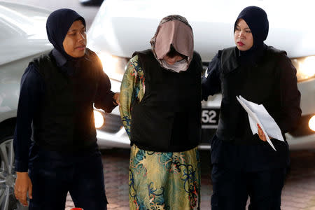 Vietnamese Doan Thi Huong, who is on trial for the killing of Kim Jong Nam, the estranged half-brother of North Korea's leader, is escorted as she arrives at the Shah Alam High Court on the outskirts of Kuala Lumpur, Malaysia August 16, 2018. REUTERS/Lai Seng Sin