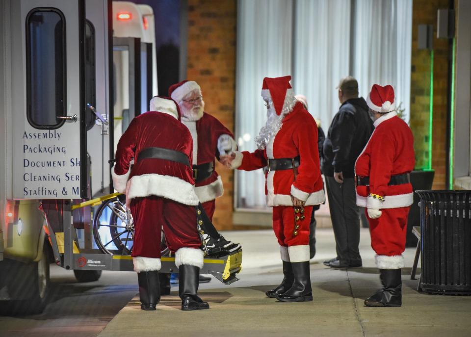 Santas line up to greet people for the Dinner with Santa event Monday, Dec. 17, in St. Cloud. 