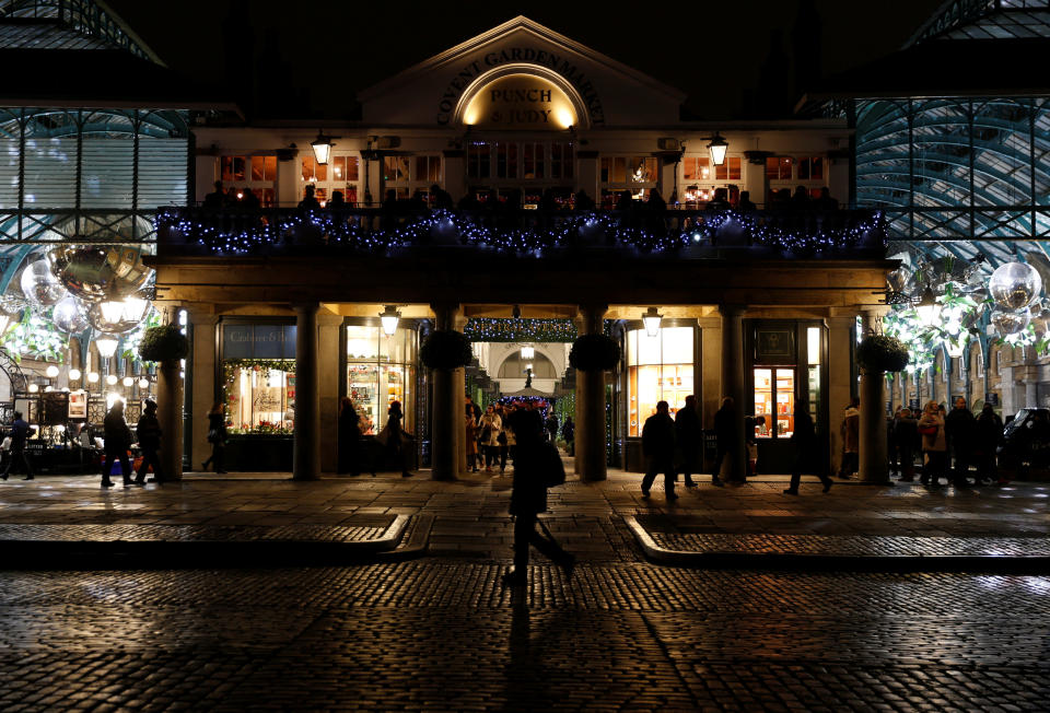 Shoppers visit a market decorated for Christmas at Covent Garden in London