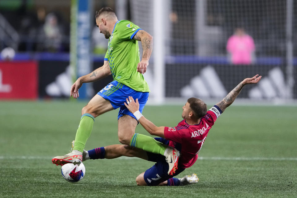 Seattle Sounders forward Jordan Morris is fouled by FC Dallas forward Paul Arriola, right, during the second half of Game 3 of a first-round MLS playoff soccer series Friday, Nov. 10, 2023, in Seattle. The Sounders won 1-0 to advance. (AP Photo/Lindsey Wasson)