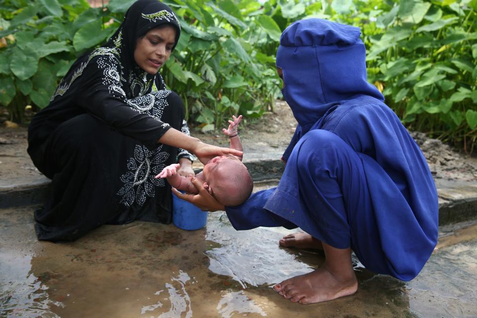 <p>Zwei Frauen, die der muslimischen Minderheit der Rohingya angehören, waschen in einem Flüchtlingslager ein einwöchiges Baby. Die jüngste Gewalt in der Unruheregion Rakhine hat schätzungsweise zehntausende Menschen in die Flucht getrieben. (Bild: Mushfiq Alam/AP/dpa) </p>