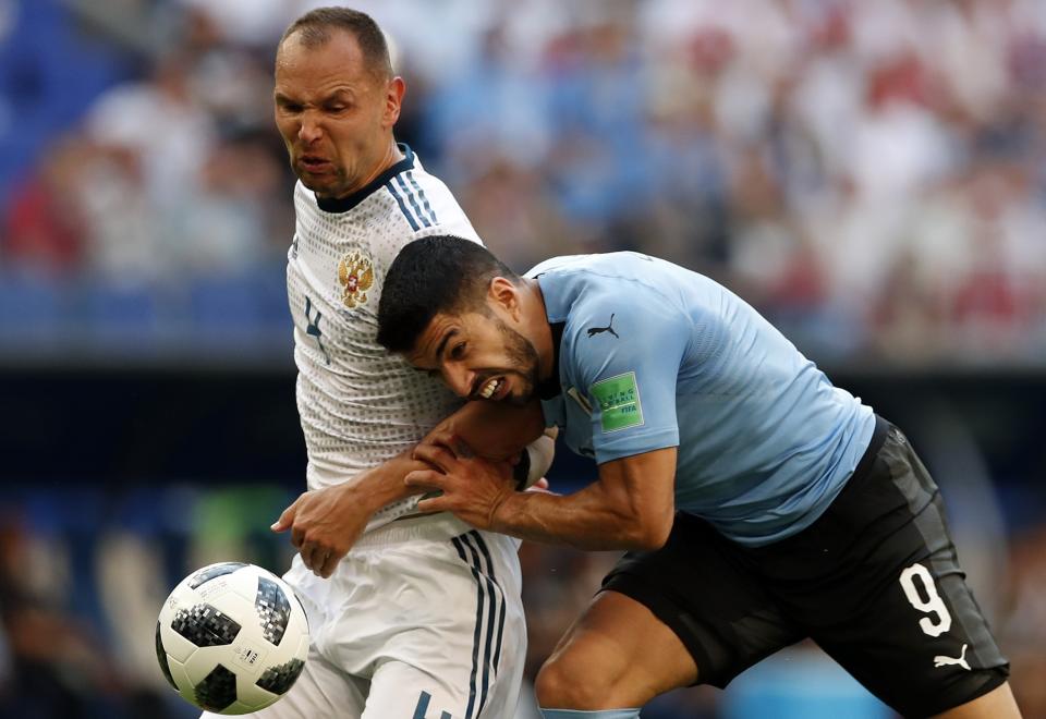 <p>Luis Suarez gets up close and personal with Russia’s Sergei Ignashevich (AP) </p>