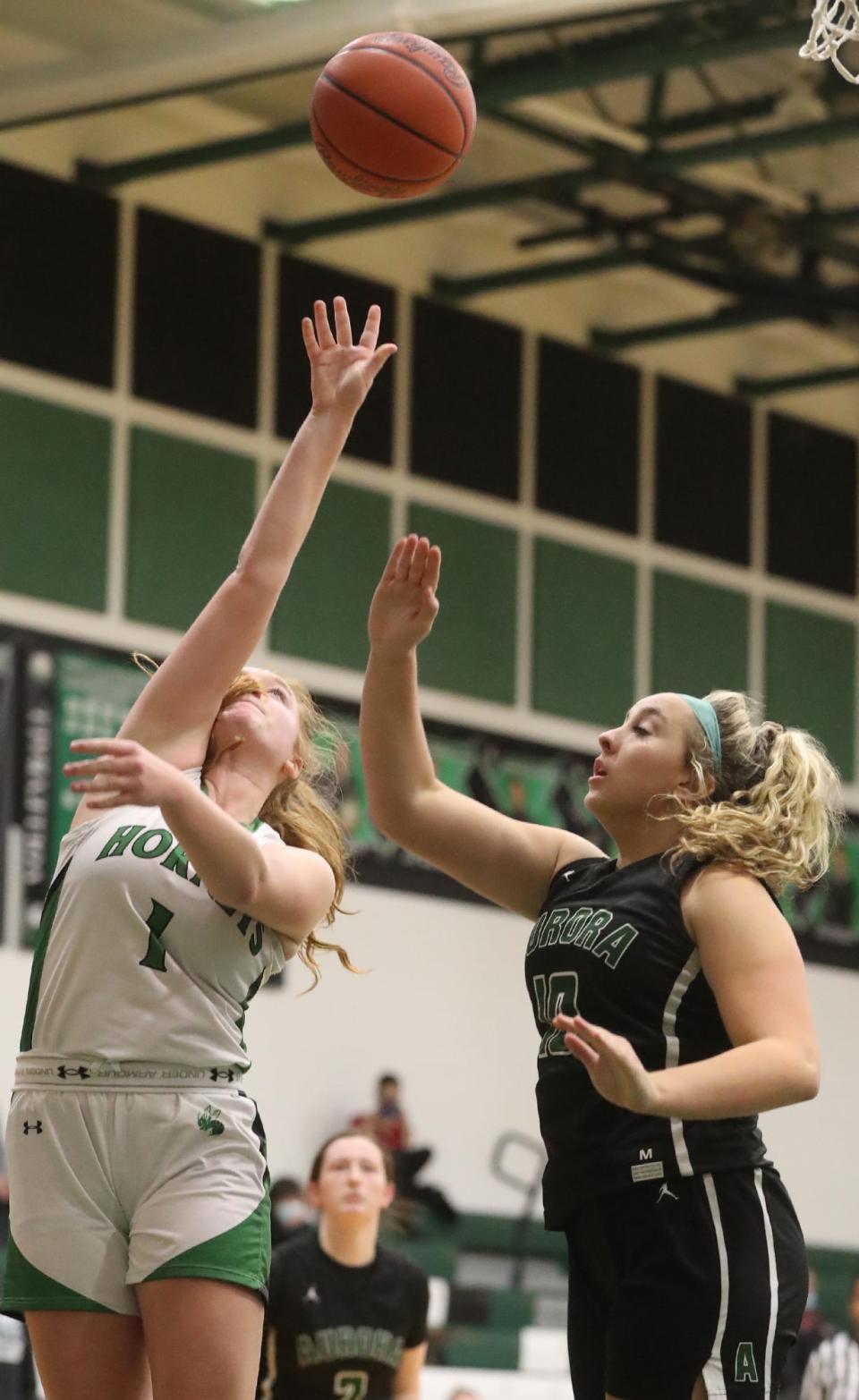 Highland's Kennedy Morgan shoots as Aurora's Grace Barbour defends during their Suburban League game at Highland High School in Medina.