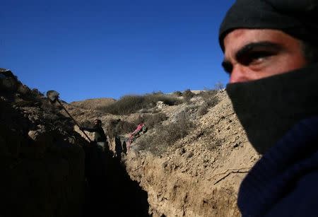 FILE PHOTO: A rebel fighter of Jaysh al-Islam digs a trench in Tal Farzat in the besieged rebel-held eastern Ghouta area of Damascus, Syria February 2, 2017. REUTERS/Bassam Khabieh