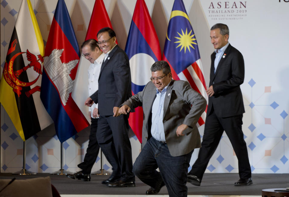 Malaysia Foreign Minister Saifuddin Abdullah, center, steps out of platform as Philippines Foreign Affaires Secretary Teodoro Locsin Jr., left, Myanmar Minister of State for Foreign Affaires Kyaw Tin, second left and Singapore Foreign Minister Vivian Balakrishnan walk after posing for group photo during the ASEAN Foreign Ministers' retreat in Chiang Mai, Thailand, Friday, Jan. 18, 2019. (AP Photo/Gemunu Amarasinghe)