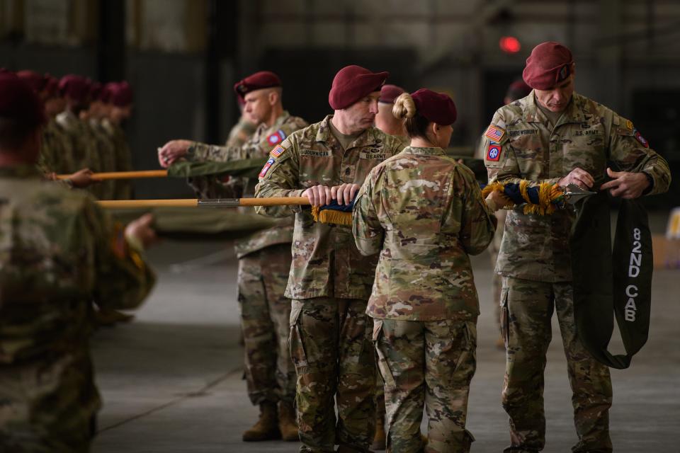 Command Sgt. Maj. James Journigan, left to right, Col. Kirsten Schwenn and Chief Warrant 5 Timothy Shrewsbury case the 82nd Combat Aviation Brigade colors during a casing ceremony on Friday, Dec. 1, 2023, ahead of its deployment to the Middle East.