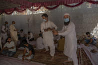 Kashmiri men carry rice plates before serving them to guests during a wedding ceremony on the outskirts of Srinagar, Indian controlled Kashmir, Friday, Sept. 18, 2020. The coronavirus pandemic has changed the way people celebrate weddings in Kashmir. The traditional week-long feasting , elaborate rituals and huge gatherings have given way to muted ceremonies with a limited number of close relatives attending. With restrictions in place and many weddings cancelled, the traditional wedding chefs have little or no work. The virus has drastically impacted the life and businesses in the region. (AP Photo/ Dar Yasin)