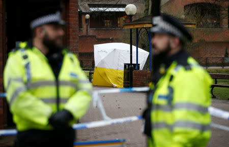 Police officers stand behind a cordon placed around a payment machine covered by a tent in a supermarket car park near to where former Russian intelligence agent Sergei Skripal and his daughter Yulia were found poisoned in Salisbury, Britain, March 13, 2018. REUTERS/Henry Nicholls