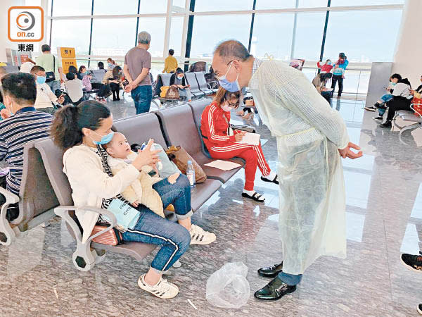 湖北<br>曾國衞在武漢天河國際機場，慰問準備返港的市民及幼童。
