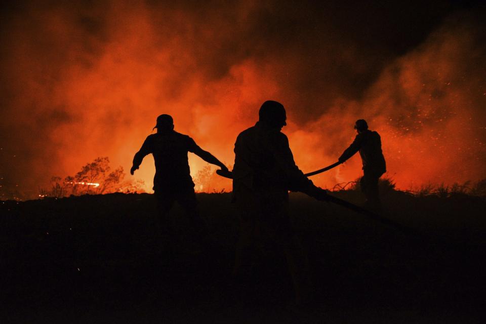 Firefighters and Local villagers try to get the fire under control in Kirli village near the town of Manavgat, in Antalya province, Turkey, early Friday July 30, 2021. The fire that continued all night could not be brought under control and people living in the village started to evacuate. Wildfires are common in Turkey's Mediterranean and Aegean regions during the arid summer months, although some previous forest fires have been blamed on arson. (AP Photo)