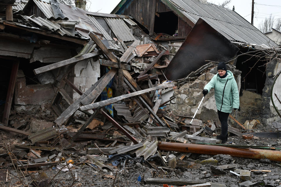 A woman stands near debris of her house following Wednesday's Russian shelling, in Kurakhove, Donetsk region, Ukraine, Thursday, Dec. 8, 2022. (AP Photo/Andriy Andriyenko)