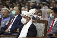 Afghan President Ashraf Ghani, center, wearing a protective face mask to help curb the spread of the coronavirus, attends an Afghan Loya Jirga meeting in Kabul, Afghanistan, Friday, Aug. 7, 2020. The traditional council opened Friday in the Afghan capital to decide the release of a final 400 Taliban - the last hurdle to the start of negotiations between Kabul’s political leadership and the Taliban in keeping with a peace deal the United States signed with the insurgent movement in February. (AP Photo/Rahmat Gul)