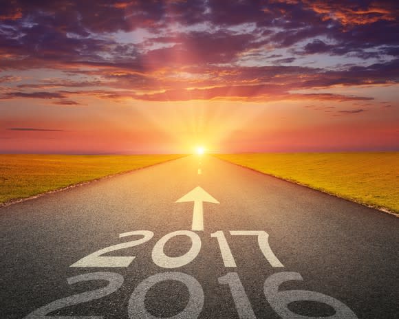 Years 2016 and 2017 written on a road, with arrow pointing down the road toward setting sun.