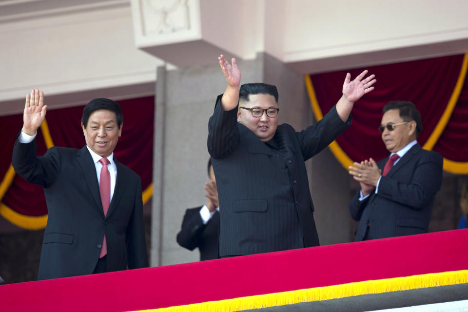 North Korean leader Kim Jong Un, right, raises his hands as he waves with China's third highest ranking official, Li Zhanshu, at left during a parade for the 70th anniversary of North Korea's founding day in Pyongyang, North Korea, Sunday, Sept. 9, 2018. North Korea staged a major military parade, huge rallies and will revive its iconic mass games on Sunday to mark its 70th anniversary as a nation. (AP Photo/Ng Han Guan)