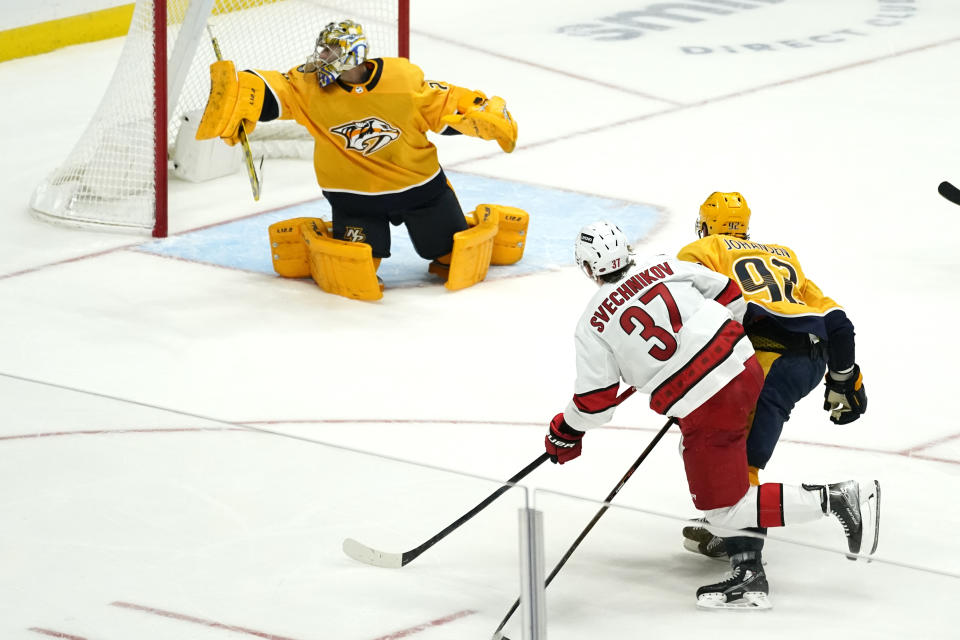 Carolina Hurricanes right wing Andrei Svechnikov (37) scores a goal against Nashville Predators goaltender Juuse Saros, top, in the third period of an NHL hockey game Saturday, Oct. 16, 2021, in Nashville, Tenn. The Hurricanes won 3-2. (AP Photo/Mark Humphrey)