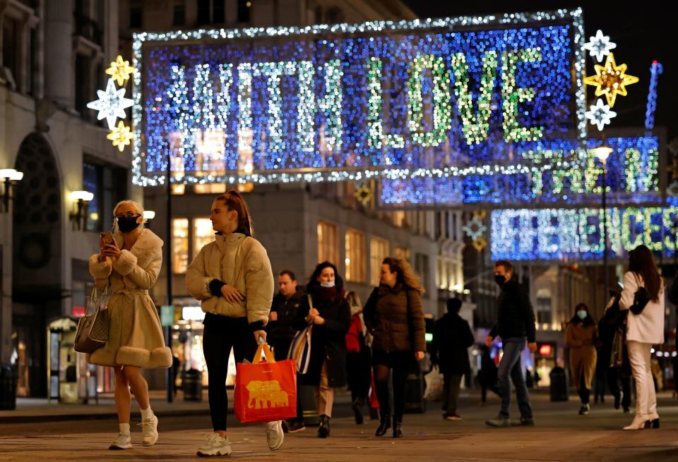 Pedestrians, some wearing face masks or coverings due to the COVID-19 pandemic, walk past Christmas lights on Oxford Street in central London on November 17, 2020. - Britain has been the worst-hit nation in Europe recording more than 50,000 coronavirus deaths from some 1.2 million positive cases. (Photo by Tolga Akmen / AFP) (Photo by TOLGA AKMEN/AFP via Getty Images)