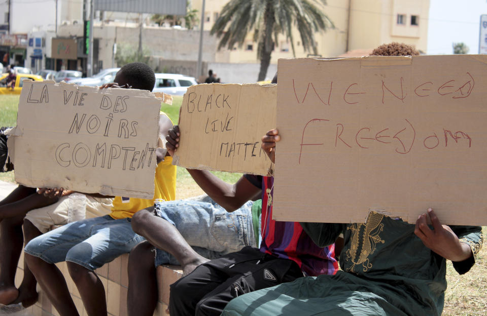 FILE - Migrants hold placards reading "Black Lives Matter", left in French, during a gathering in Sfax, Tunisia's eastern coast, on July 7, 2023. Migrants who flooded into Tunisia's port city of Sfax aiming to make Europe their new home are now sharing the burden and the blame for an escalating crisis deeply tinged with racism among some Tunisians amid fears of European leaders trying to stanch the flow to their shores. (AP Photo, File)