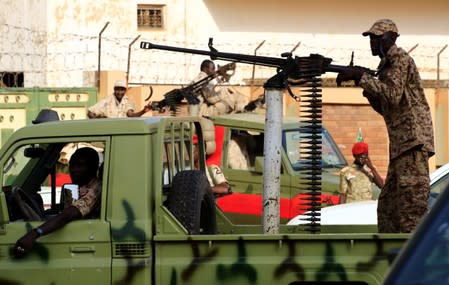 Sudanese soldiers secure the area as Sudan's ex-president Omar al-Bashir leaves the office of the anti-corruption prosecutor in Khartoum