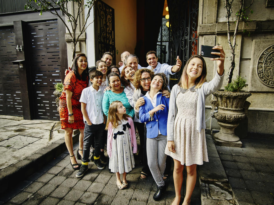 Girl taking selfie with her family in front of a restaurant