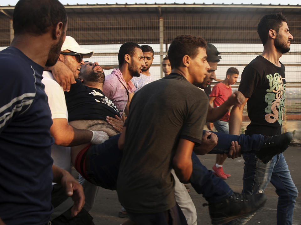 Protesters evacuate a wounded a man during a protest at the entrance of Erez border crossing between Gaza and Israel, in the northern Gaza Strip, Tuesday, Sept. 4, 2018. The Health Ministry in Gaza says several Palestinians were wounded by Israeli fire as they protested near the territory's main personnel crossing with Israel. (AP Photo/Adel Hana)