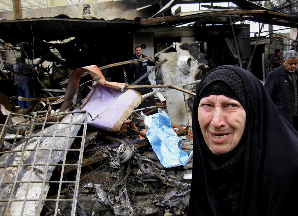 An Iraqi woman looks at damages from Monday's car bomb explosion at an outdoor market in Abu Disher neighborhood of southern Baghdad, Iraq, Tuesday, Feb. 4, 2014. Iraqi officials say car bombings on Monday in and near Baghdad have killed and wounded scores of people. (AP Photo/Khalid Mohammed)